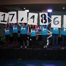 Students holding large number signs at fundraising event.