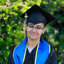 Smiling Liliana Flores in UCR cap and gown.
