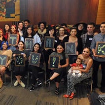 Foster youth students holding "thank you" sign at holiday gathering.
